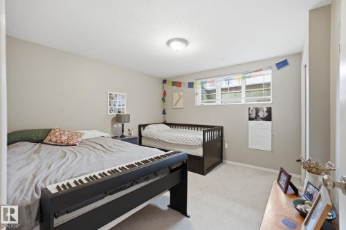 This room features light-colored walls and carpeting, a window with blinds, and a ceiling light fixture - 7235 112 Street, Edmonton, AB - Indoor Photo Showing Bedroom