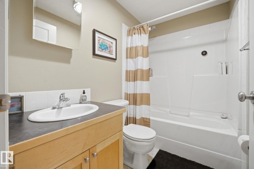 The bathroom features a vanity with a counter and a basin, a toilet, and a bathtub with a shower - 7235 112 Street, Edmonton, AB - Indoor Photo Showing Bathroom
