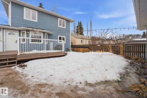 The property features a two-story exterior with blue siding and white trim, complemented by a brown deck with white railings - 7235 112 Street, Edmonton, AB - Outdoor With Exterior