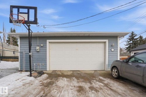 Detached garage with a white panel garage door and light blue siding - 7235 112 Street, Edmonton, AB - Outdoor With Exterior