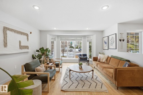 Living room featuring hardwood floors, recessed lighting, and a bay window providing natural light - 7235 112 Street, Edmonton, AB - Indoor Photo Showing Living Room