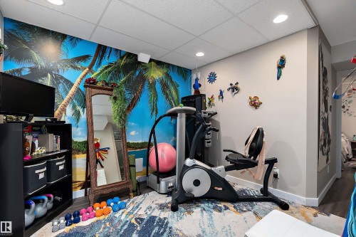 This versatile space features a vibrant wall mural, recessed lighting, and a neutral wall color, providing a dynamic backdrop for various activities - 2914 18A Avenue, Edmonton, AB - Indoor