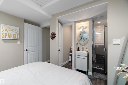Bathroom with a vanity sink, oval mirror, and a shower with subway tile - 2914 18A Avenue, Edmonton, AB - Indoor Photo Showing Bedroom