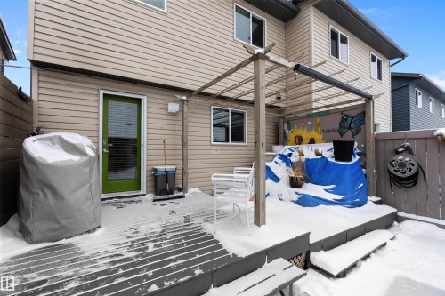 The property features a back deck with a privacy fence and a green rear door - 2914 18A Avenue, Edmonton, AB - Outdoor With Exterior
