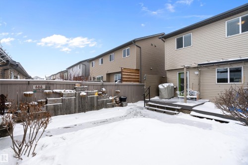 The property features an exterior deck with railings, a light-colored exterior, and multiple windows - 2914 18A Avenue, Edmonton, AB - Outdoor With Deck Patio Veranda With Exterior