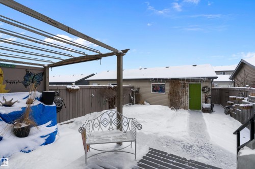 The property features a fenced yard, a detached outbuilding with a bright green door, and an overhead pergola structure - 2914 18A Avenue, Edmonton, AB - Outdoor