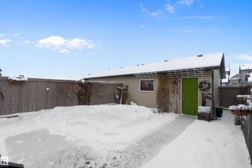 The property features a fenced yard, a detached outbuilding with a bright green door, and a paved pathway - 2914 18A Avenue, Edmonton, AB - Outdoor