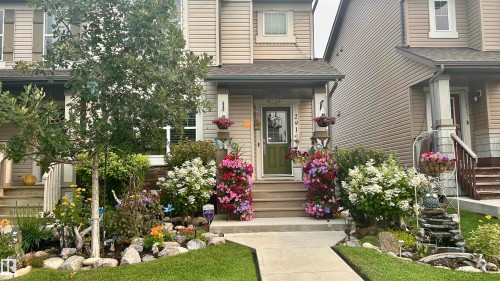The property features an inviting front exterior with a green front door and a well-maintained garden area - 2914 18A Avenue, Edmonton, AB - Outdoor With Facade