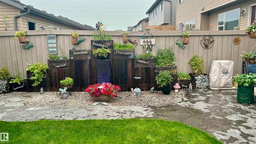 The property features a well-maintained yard with a lawn and a decorative garden area - 2914 18A Avenue, Edmonton, AB - Outdoor With Deck Patio Veranda