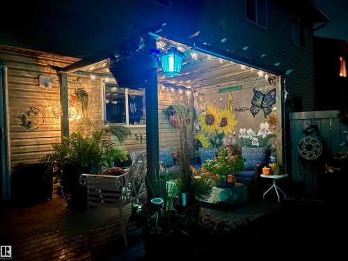 The property features an inviting covered patio with string lighting, painted murals, and decorative plants - 2914 18A Avenue, Edmonton, AB - Outdoor