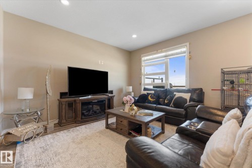 The living area features a large window, a television with an electric fireplace, and recessed lighting - 79 17635 58 Street, Edmonton, AB - Indoor Photo Showing Living Room