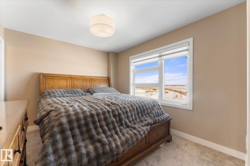 This room features light-colored walls, carpeted floors, and a window providing natural light and views of the surrounding landscape - 79 17635 58 Street, Edmonton, AB - Indoor Photo Showing Bedroom