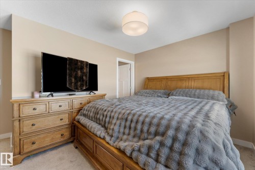 This room features neutral-toned walls, a light fixture on the ceiling, and carpeted flooring - 79 17635 58 Street, Edmonton, AB - Indoor Photo Showing Bedroom