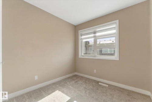 This room features carpeted flooring, light-colored walls, and a window with blinds - 79 17635 58 Street, Edmonton, AB - Indoor Photo Showing Other Room