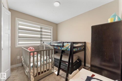 This room features neutral-toned walls, a window with horizontal blinds, and carpeting - 79 17635 58 Street, Edmonton, AB - Indoor Photo Showing Bedroom