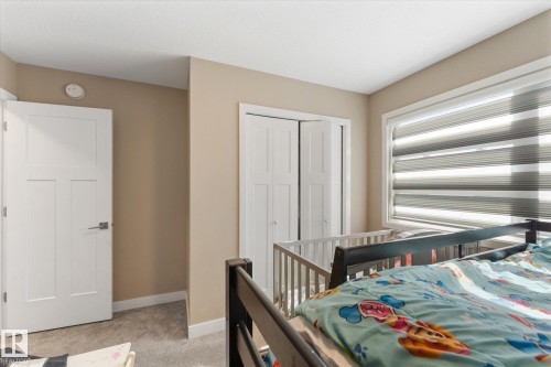 This room features neutral-toned walls, a white door with a modern handle, and a window with blinds - 79 17635 58 Street, Edmonton, AB - Indoor Photo Showing Bedroom