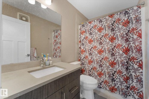 Bathroom featuring a vanity with an integrated sink, a large mirror, and overhead lighting - 79 17635 58 Street, Edmonton, AB - Indoor Photo Showing Bathroom