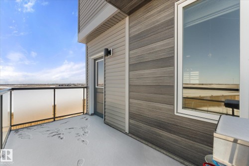 The property features an exterior balcony with glass panel railings and a view of the surrounding area - 79 17635 58 Street, Edmonton, AB - Outdoor With Balcony With Exterior