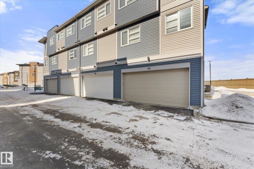 The property features a multi-story exterior with horizontal siding in shades of blue and tan, complemented by white-framed windows - 79 17635 58 Street, Edmonton, AB - Outdoor
