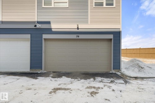 The property features a garage with a light-colored door and a visible numerical address above - 79 17635 58 Street, Edmonton, AB - Outdoor With Exterior
