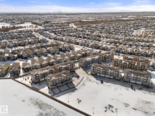Aerial perspective highlighting the surrounding neighborhood with numerous properties featuring varied rooflines and a distant skyline - 79 17635 58 Street, Edmonton, AB - Outdoor With View