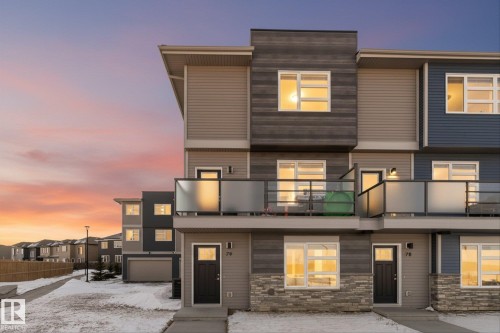 The property features a modern exterior with varied siding materials and a stone facade accent - 79 17635 58 Street, Edmonton, AB - Outdoor With Balcony