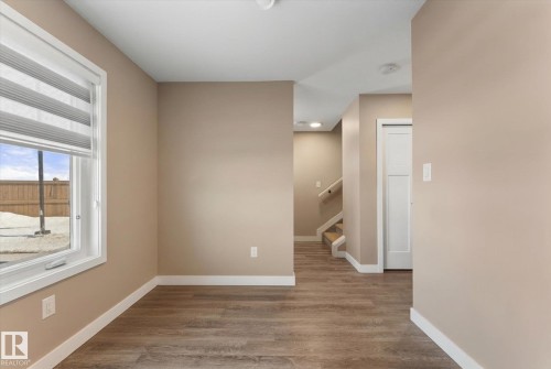 This space features durable wood-look flooring, light-colored walls, and white trim - 79 17635 58 Street, Edmonton, AB - Indoor Photo Showing Other Room