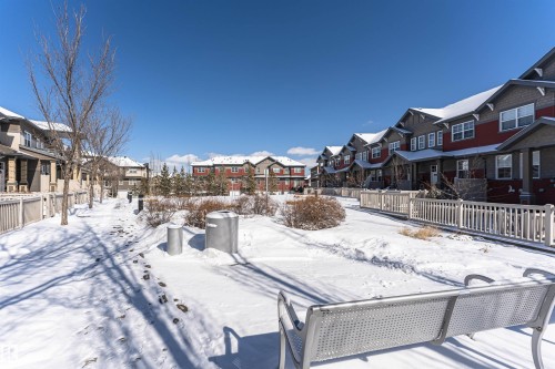 The property is located within a community featuring residential buildings with varied architectural styles, some with red siding and others with gray siding - 31 4029 Orchards Drive, Edmonton, autreother - Outdoor