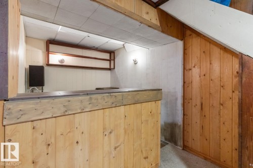 The property features a built-in bar area with wood paneling and an overhead shelf - 242 Primrose Gardens, Edmonton, AB - Indoor