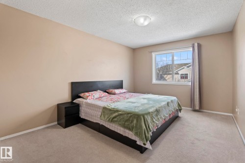 Bedroom featuring light neutral-toned walls, a window with curtains, and carpeting - 92 4350 23 Street Nw, Edmonton, AB - Indoor Photo Showing Bedroom
