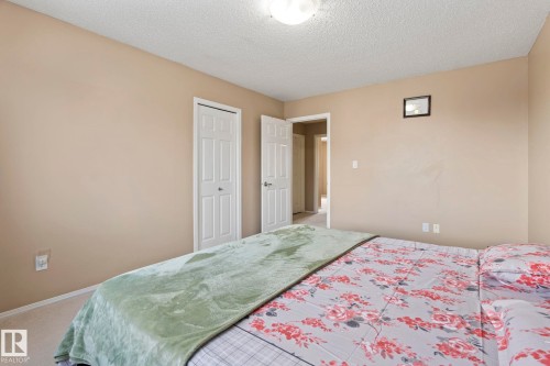 This room features light beige walls and white trim, with two white paneled doors visible - 92 4350 23 Street Nw, Edmonton, AB - Indoor Photo Showing Bedroom