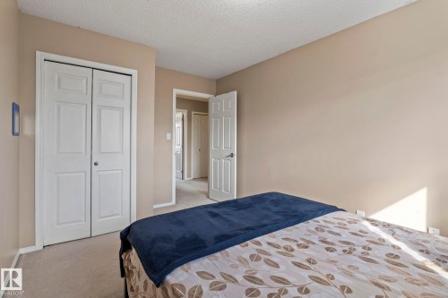 The room features carpeted flooring, a closet with bi-fold doors, and neutral-toned walls - 92 4350 23 Street Nw, Edmonton, AB - Indoor Photo Showing Bedroom