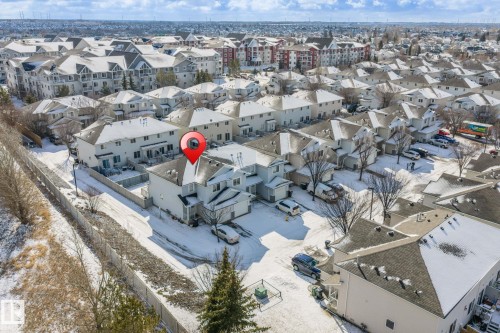 Aerial view showcasing the property situated within a residential community, featuring a mix of townhouses and multi-story apartment buildings - 92 4350 23 Street Nw, Edmonton, AB - Outdoor With View