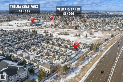 Aerial view of the property's community, featuring residential buildings, a wide road, and surrounding open areas with sparse trees - 92 4350 23 Street Nw, Edmonton, AB - Outdoor With View