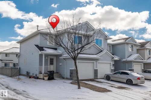 The property features light blue siding, a covered entryway, and two attached garage spaces - 92 4350 23 Street Nw, Edmonton, AB - Outdoor With Facade