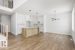 Open concept living space featuring wide plank flooring and a contemporary chandelier - 