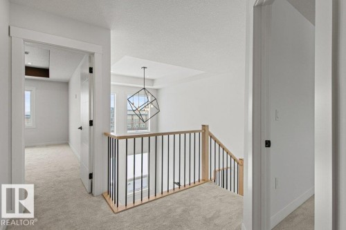 The property features light-colored carpeting, white walls, and white trim throughout - 5018 53 Avenue, Calmar, AB - Indoor Photo Showing Other Room