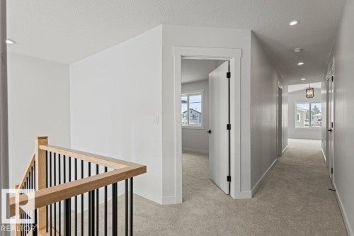 The property offers a light-filled interior with carpeted flooring, white walls, and recessed lighting - 5018 53 Avenue, Calmar, AB - Indoor Photo Showing Other Room