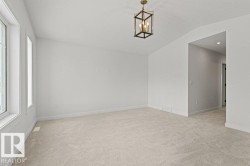 This room features light-colored carpeting, white walls, and a contemporary ceiling light fixture - 