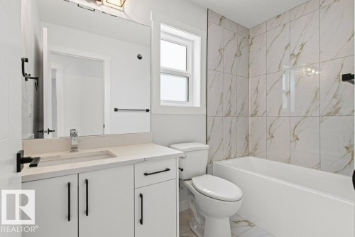 The bathroom features a vanity with a rectangular sink, a mirror, and a toilet - 5018 53 Avenue, Calmar, AB - Indoor Photo Showing Bathroom