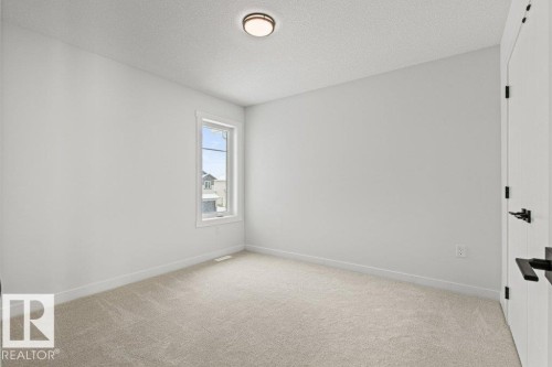 This room features a window providing natural light, light-colored carpeting, and a ceiling-mounted light fixture - 5018 53 Avenue, Calmar, AB - Indoor Photo Showing Other Room