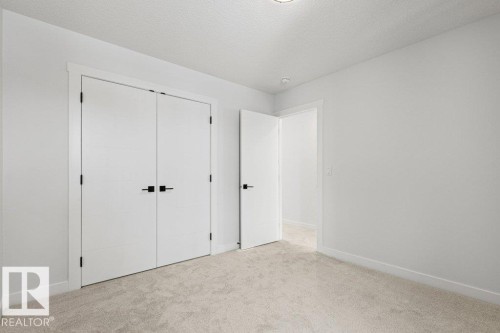 The room features light-colored carpeting, white walls, and white trim - 5018 53 Avenue, Calmar, AB - Indoor Photo Showing Other Room