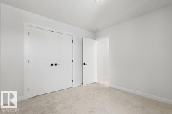 The room features light-colored carpeting, white walls, and white trim - 