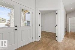 The property features a bright entryway with a white front door that includes clear glass panels - 