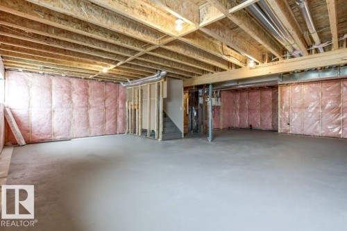 The property features a spacious, unfinished basement with exposed wooden joists and concrete flooring, offering substantial potential for future customization - 5018 53 Avenue, Calmar, AB - Indoor Photo Showing Basement