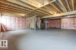 The property features a spacious, unfinished basement with exposed wooden joists and concrete flooring, offering substantial potential for future customization - 