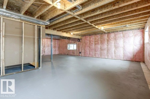 The property features an unfinished basement with exposed wooden joists, a poured concrete floor, and insulation visible on the exterior walls, offering potential for customization - 5018 53 Avenue, Calmar, AB - Indoor Photo Showing Basement