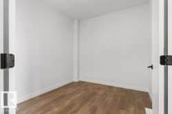 This room features light wood flooring, white walls, and white trim - 