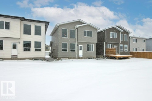 The property features a spacious backyard with a wooden deck and a wooden privacy fence - 5018 53 Avenue, Calmar, AB - Outdoor