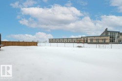 The property features an expansive yard area, bordered by a wooden fence on one side and a chain link fence on the other - 